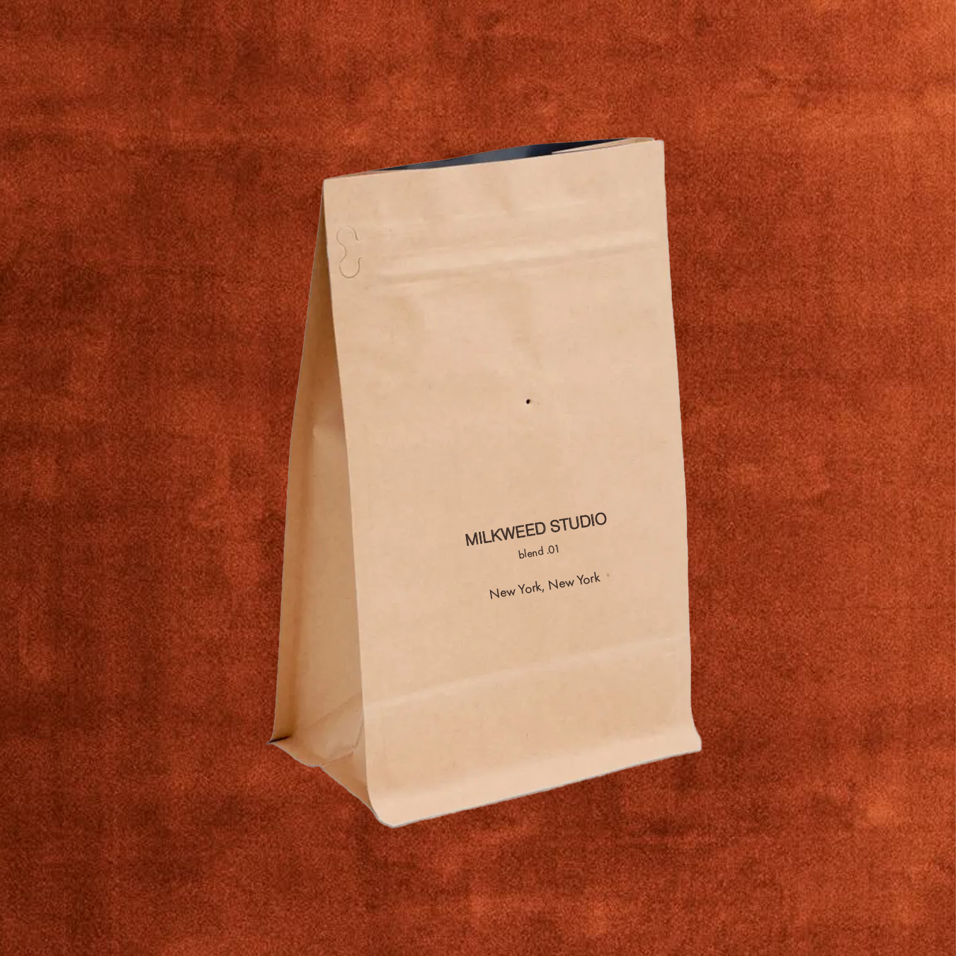 a 12 oz Kraft bag of coffee with milkweed studio stamped on it
